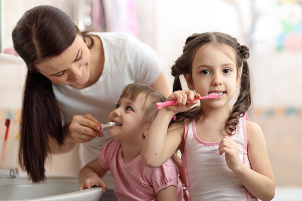 Gyermekek fogat mosnak szülővel